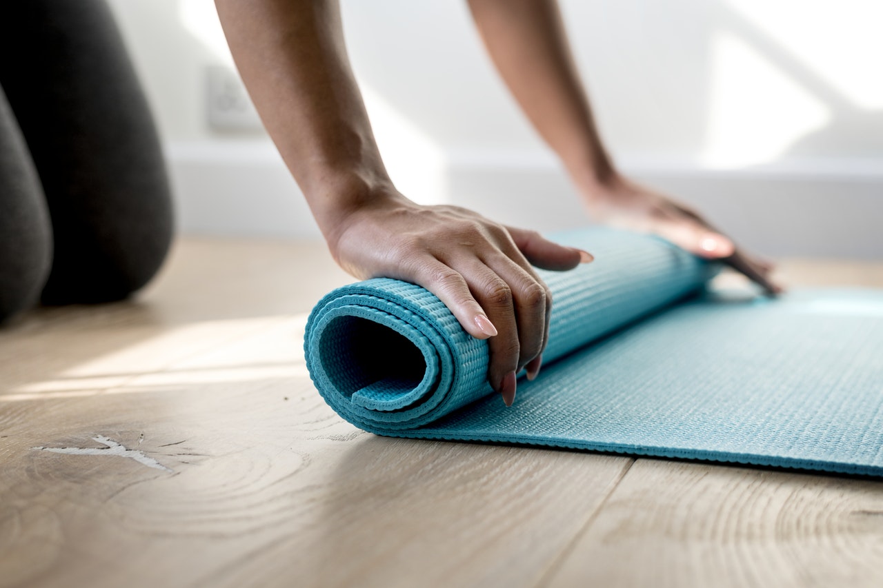 a person folding mattress on the floor